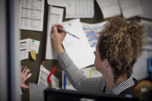 A woman writing notes in the school office.