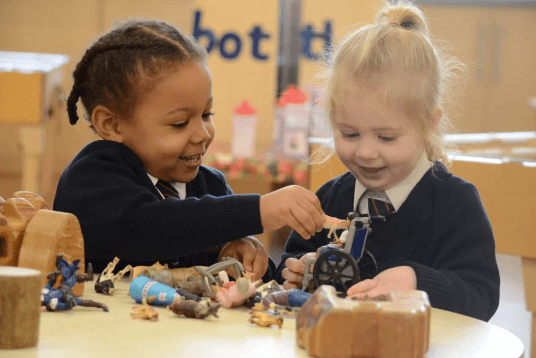 2 pupils playing with toys