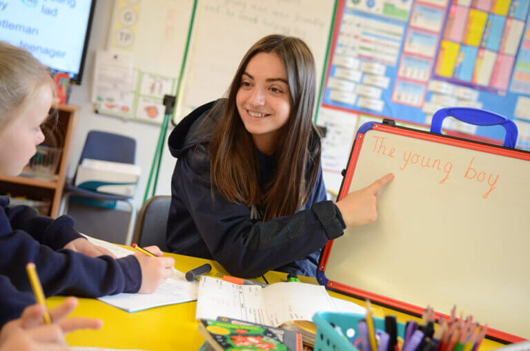 school teacher points to white board