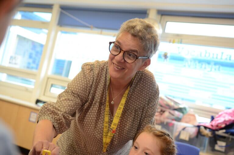 A teacher smiling in the classroom.