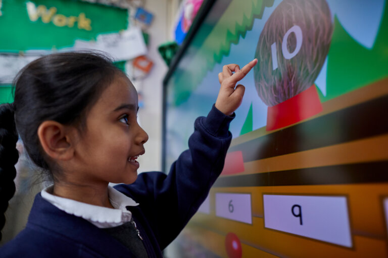 A girl tapping the number ten on a computer screen.