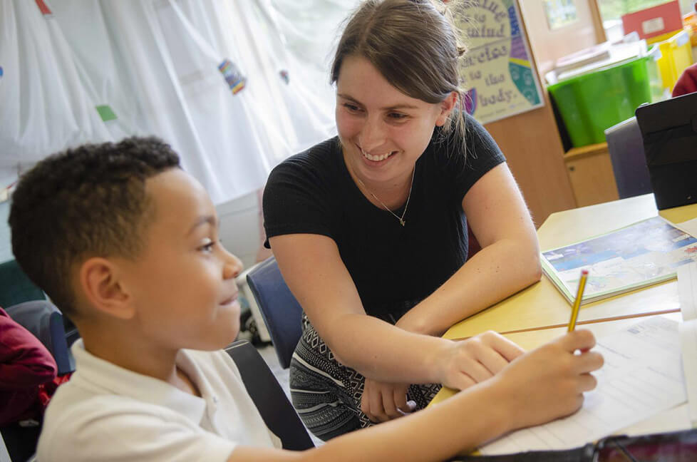 Pupil and teacher looking at activity papers