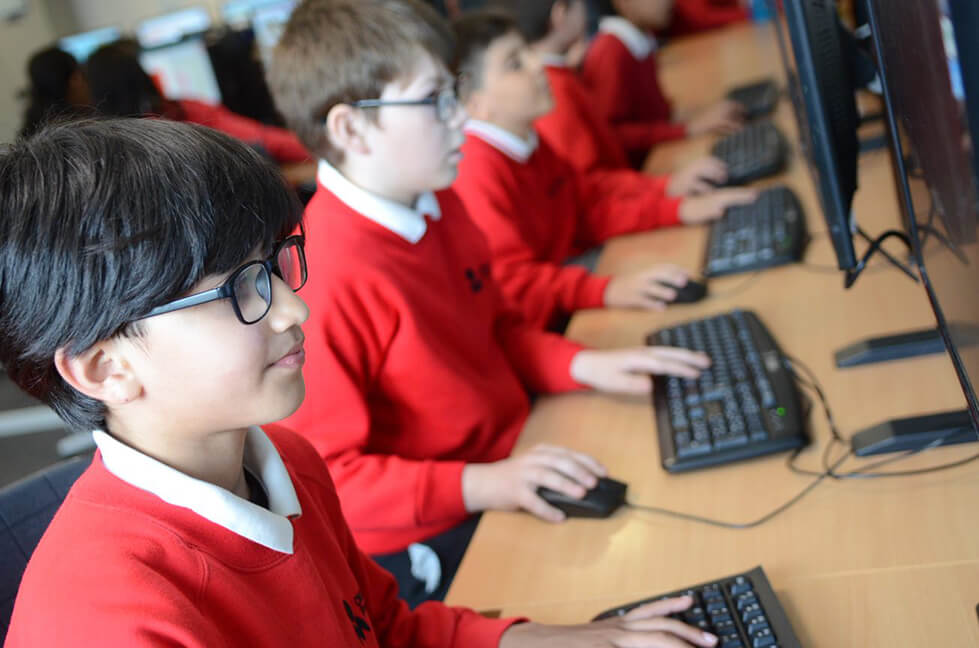 Pupils working on PC during ICT lesson