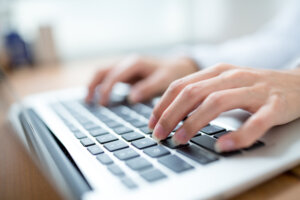 Hands typing on a laptop.