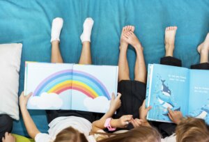 Children sitting together and reading books on their laps.