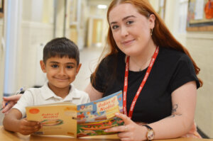 pupil and teacher holding book