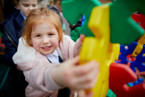 A young girl playing on outdoor equipment in the playground.