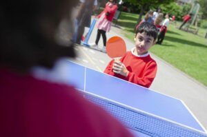 Boy pupil playing table tennis outdoor