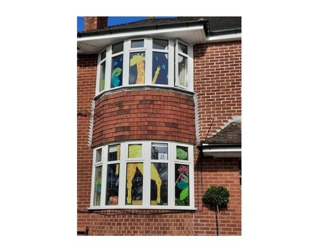 An illustrated giraffe decorating house windows.