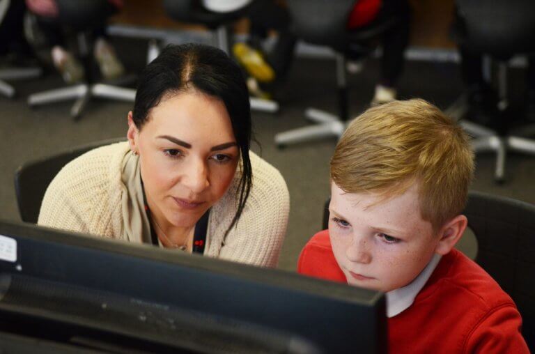 Teacher and pupil looking at a computer.