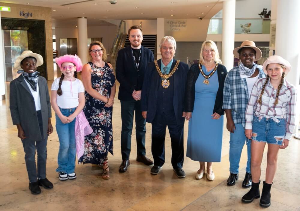 From left to right, Rachel Foster, One Education Director of HR & Education Strategy, Adam Cooke, Head of One Education Music, and Lord Mayor of Manchester, Cllr Paul Andrews, and Lady Mayoress, Karen Andrews, with children from Manchester schools at the Big 'Country' Sing 2024.