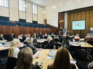 Delegates gathered in the main hall, listening to an expert speaker.